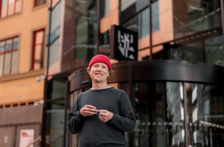 Person med rød lue foran kristiania campus