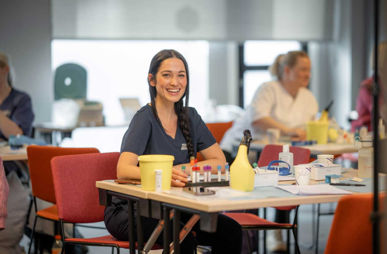Smilende kvinnelig student på laboratoriekurs 