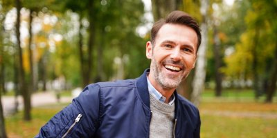 Web_Artikkel 10_Bygg kompetanse gradvis Voksen mann smiler og står ute i en park