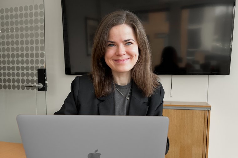 Blid kvinne ved en pc 