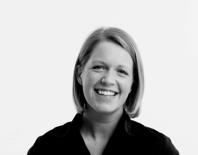 Smilende kvinne med kort hår i svart-hvitt portrett.
