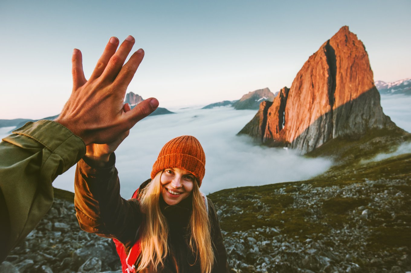 Glad jente på fjelltur gir high five