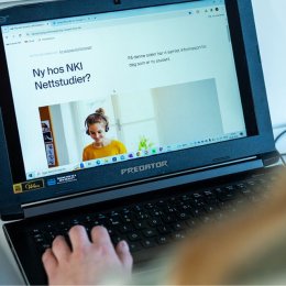 Person ser på NKI Nettstudier på en bærbar datamaskin.