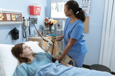 helsepersonell måler puls på en liggende pasient