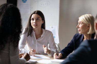 Tre kvinner diskuterer energioptimalisering og bærekraft i et møte.