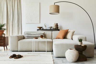 Moderne stue med beige sofa, minimalistisk innredning og buet gulvlampe.