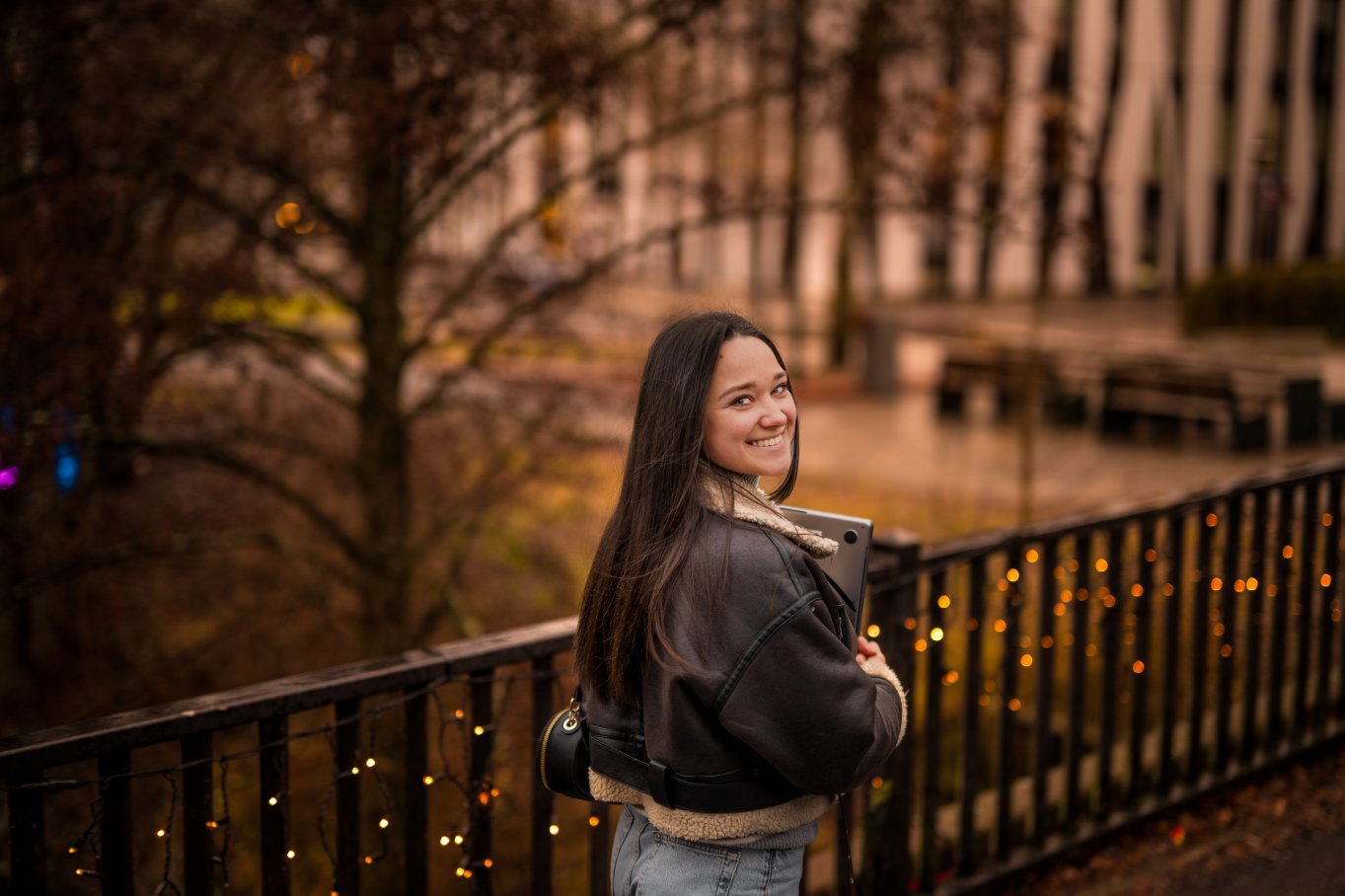 Kvinne smiler til kamera med ryggen til