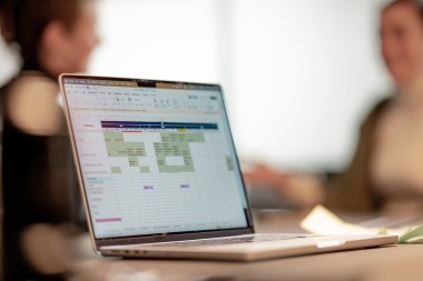 Bilde av en PC med medarbeidere i bakgrunnen