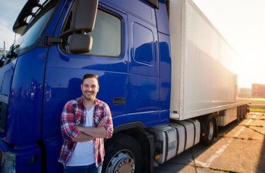 En smilende mann står utenfor lastebilen sin 