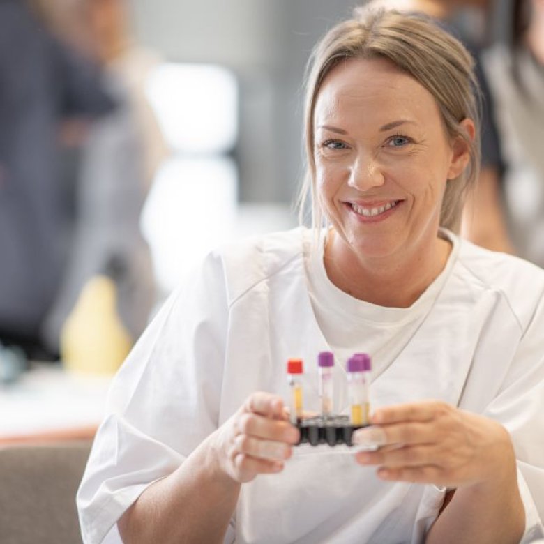 Kvinne på lab smiler til kamera