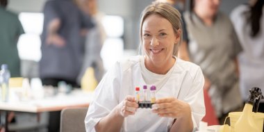 Kvinne på lab smiler til kamera