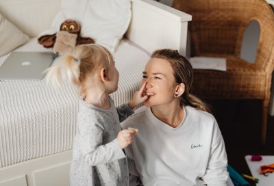 dame sitter på gulvet og leker med barn 