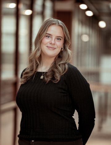 Kvinne i sort genser ser i kamera