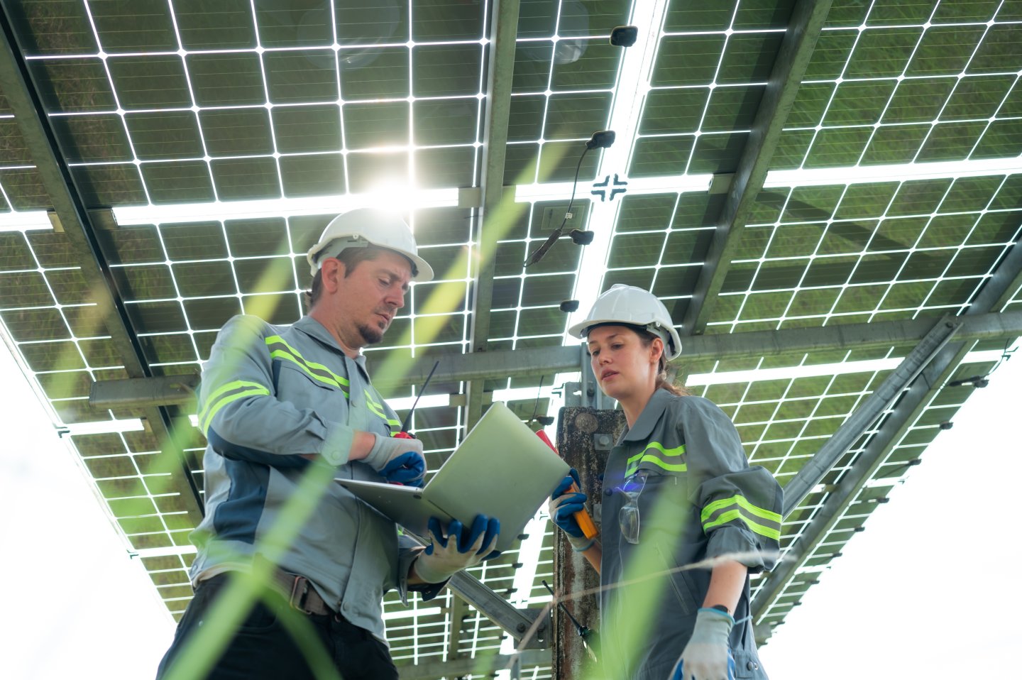 En mann og en kvinne arbeider under solcellepanel 