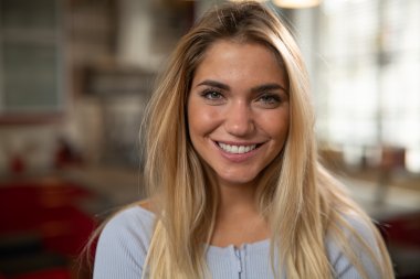 Kvinnelig, blond nettstudent smiler mot kamer