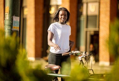 Spesiell studiekompetanse Student med sykkel ute i vårlige omgivelser