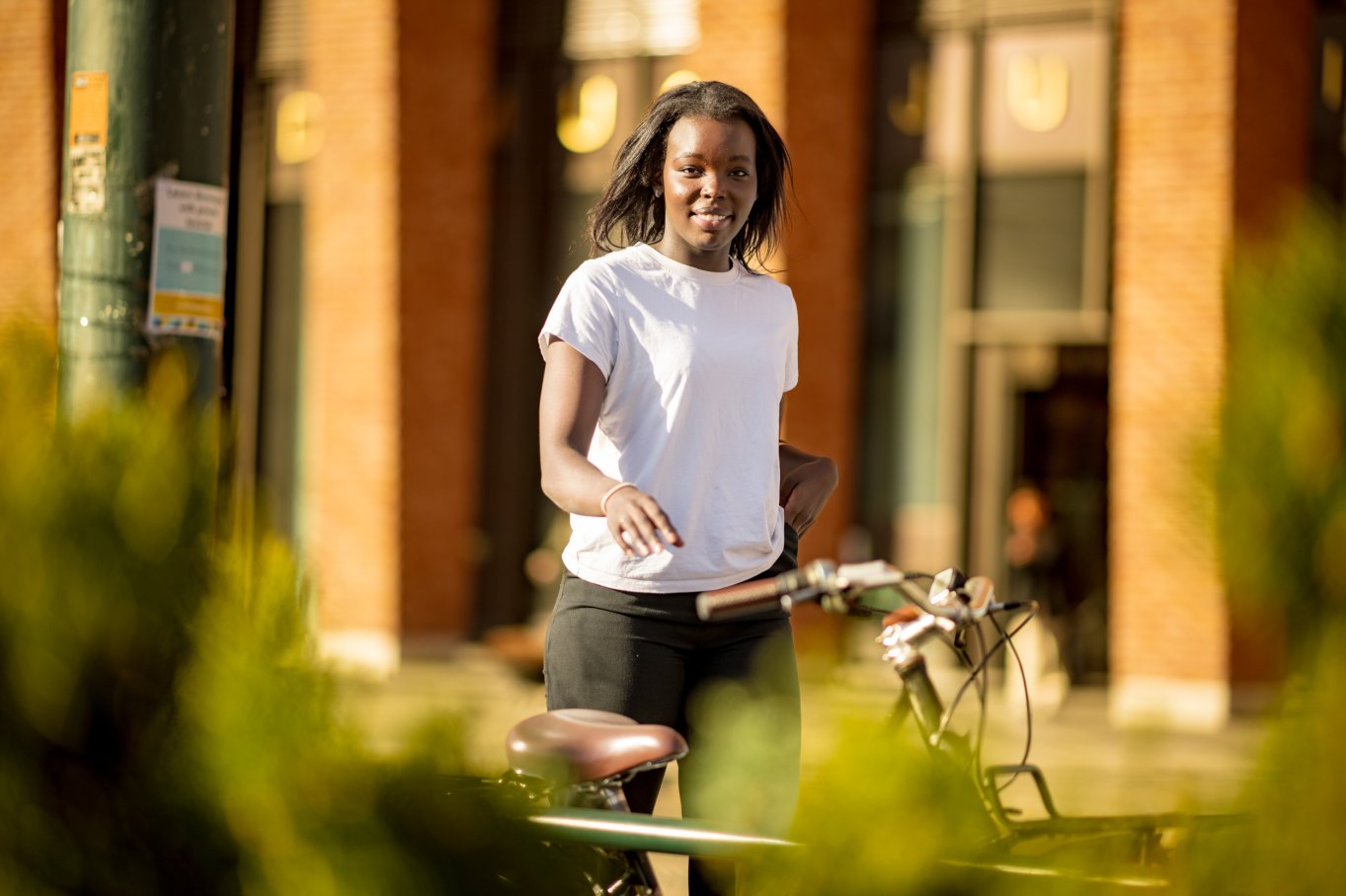 Student med sykkel ute i vårlige omgivelser